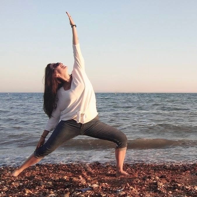 Claire, founder of Serene & Strong, practising yoga by the sea